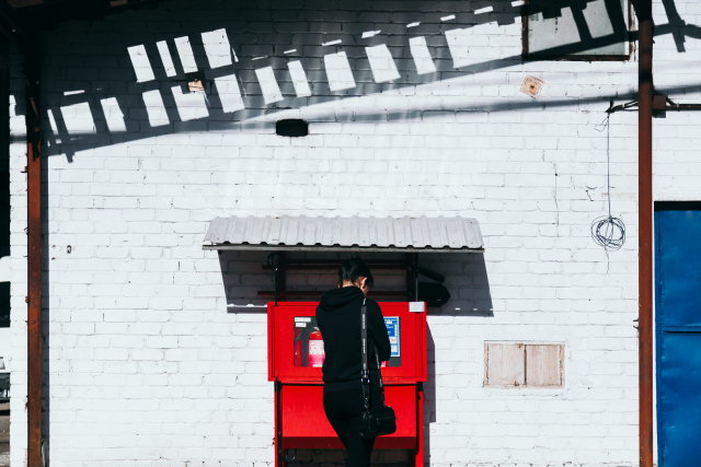 Woman in front of a red ATM